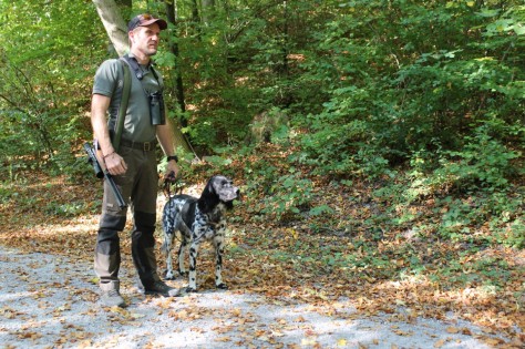 Der Wildhüter Fabian Kern mit seinem Hund auf einem Waldweg.