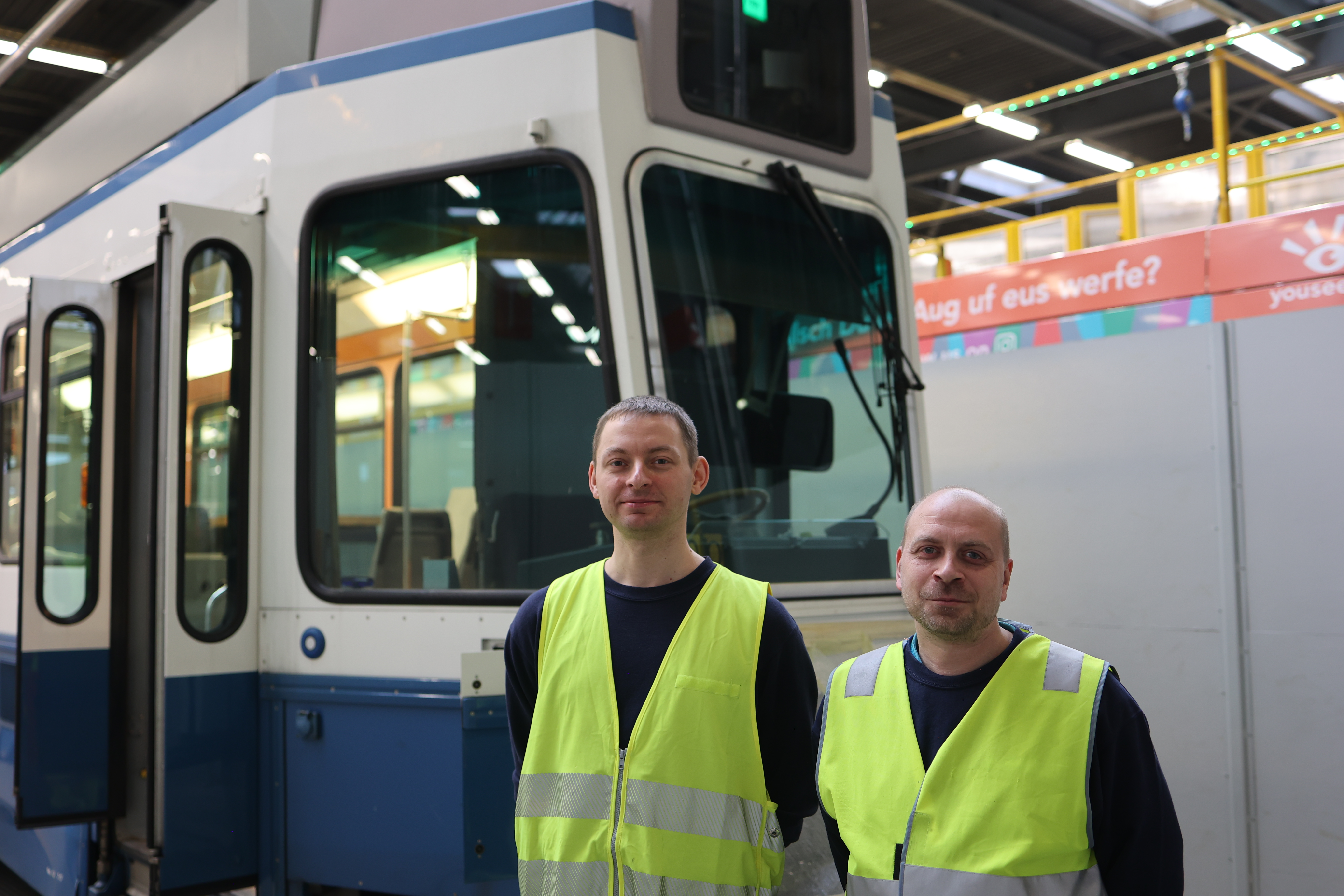 Zwei Praktikanten aus der Ukraine vor Tram 2000. 