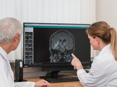 Ein Ärztin und eni Arzt besprechen einen Hirn-Scan.