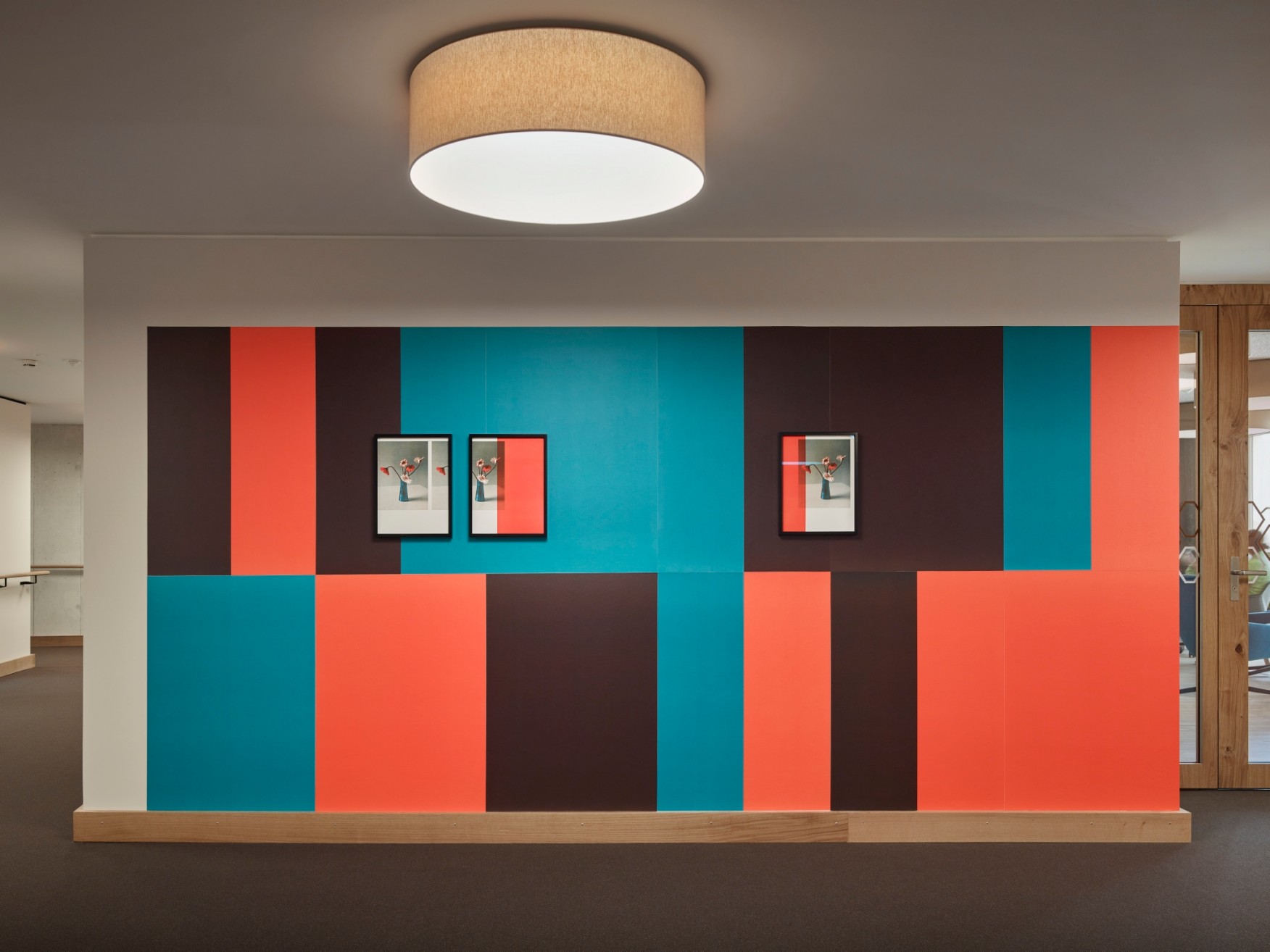 Drei Kunstwerke auf farbig tapezierter Wand