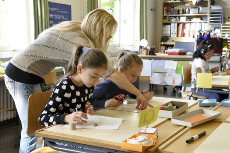 Kinder werden von einer Lehrperson unterstützt