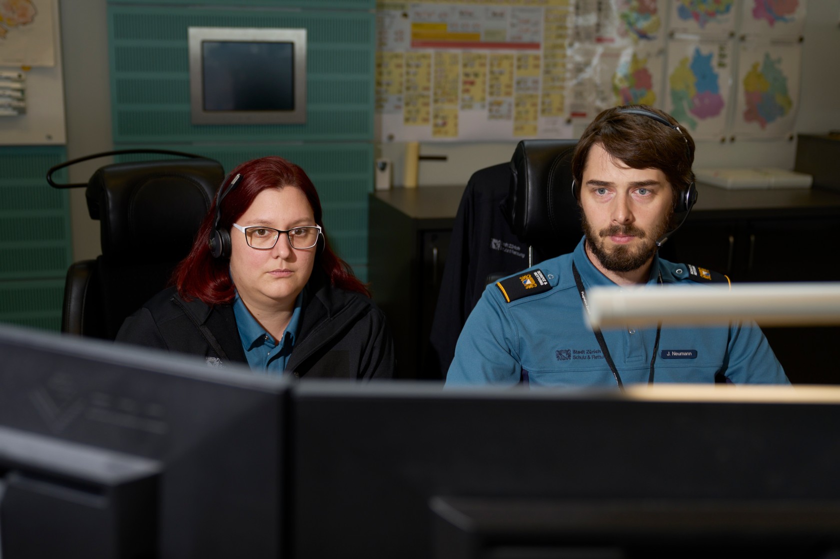 Mitarbeitende bei der Arbeit in der Einsatzzentrale von Schutz & Rettung in Uniform.